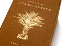 metallic gold foil stamping of palm tree and Jubaea Estate logo against brown Timbertuff Pilgrim cover material